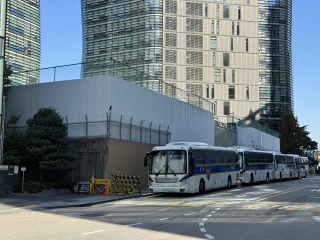 Bussen en hekjes als barrière naast de hoge muren